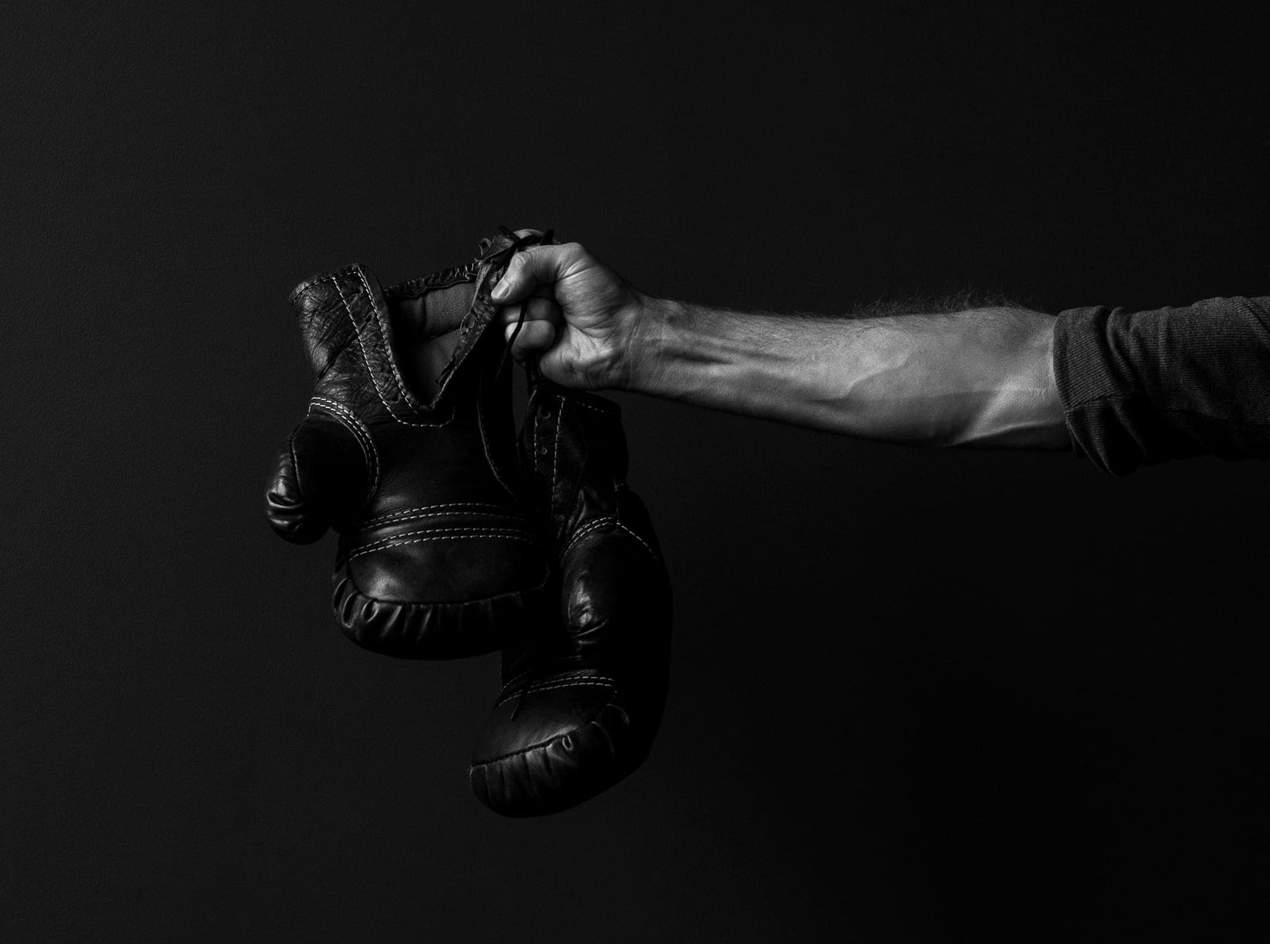 Guantes de boxeo colgando de una mano